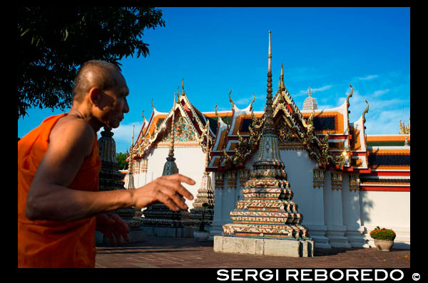 Monje budista dentro de templo de Wat Pho, Bangkok, Tailandia. Wat Pho (Templo del Buda Reclinado), o Wat Phra Chetuphon, se encuentra detrás del Templo del Buda de Esmeralda y una cita obligada para cualquier visitante por primera vez en Bangkok. Es uno de los mayores complejos de templos de la ciudad y famoso por su gigantesco Buda reclinado que mide 46 metros de largo y está cubierto de pan de oro. Es un fácil paseo de diez minutos entre aquí y el Gran Palacio, y se recomienda a venir a Wat Pho segundo, porque a pesar de que el Buda de oro aquí es tan populares que muchas personas no se toman el tiempo para pasear por el resto del complejo, así la experiencia tiende a ser mucho más relajante. Esto también es un gran lugar para disfrutar de un masaje tradicional tailandés. Wat Pho es a menudo considerada la principal escuela de masaje en Tailandia, por lo que realmente están en buenas manos aquí. Desde diciembre de 2012, entrada al templo cuesta 100 baht y se puede visitar en cualquier momento 08:00-17:00.