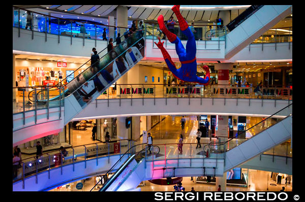 Centro comercial Centralworld. Bangkok. Tailandia. Un colgando estatuilla Spider-Man aparece en un comercial centro comercial de Bangkok. Para celebrar el lanzamiento de la película The amazing Spider-Man 2 en Bangkok, un centro comercial centro comercial muy conocido muestra una enorme colgando estatuilla de Spider-Man. El centro comercial es el más grande de Bangkok, con cientos de tiendas. CentralWorld mega-complejo comercial ofrece una de las más emocionantes experiencias de compras en Bangkok. Lo tiene todo, desde tiendas de ropa de marca, moda funky, aparatos de alta tecnología, librerías y mobiliario de diseño para tiendas de comestibles importados, un cartel de bancos, salones de belleza, restaurantes gourmet e incluso una pista de patinaje sobre hielo. Con tantas opciones tentadoras para explorar, fácilmente podría pasar medio día aquí sin darse cuenta. Vendrá como ninguna sorpresa para nadie que ha experimentado el increíble tamaño de CentralWorld que se trata, de hecho, el centro comercial más grande de Tailandia y uno de los más grandes del mundo. Creemos que es seguro decir que si usted está buscando una solución de compras en Bangkok este lugar va a entregar. Ocupando unos 550.000 metros cuadrados de espacio comercial y un tamaño de la superficie total de 830.000 metros cuadrados - que es 30% más grande que cualquier otro centro comercial en el centro de Bangkok - CentralWorld tiene una gama de ofertas que abarcan más de 500 tiendas, 100 restaurantes y cafés, 15 salas de cine, zona para niños y centro de aprendizaje (Genius Zona Planeta), dos grandes almacenes ancla, así como un patio de comidas de moda, un supermercado y un amplio cuadrados al aire libre para eventos a gran escala como parte de cuenta regresiva del Año Nuevo oficial de Bangkok. La ubicación es slap-bang en el corazón de 'campo de batalla de los centros comerciales' la Chidlom con Skytrain (BTS) el acceso directo y el hogar de los dos santuarios famosos, Santuario de Erawan y Trimurti Santuario.