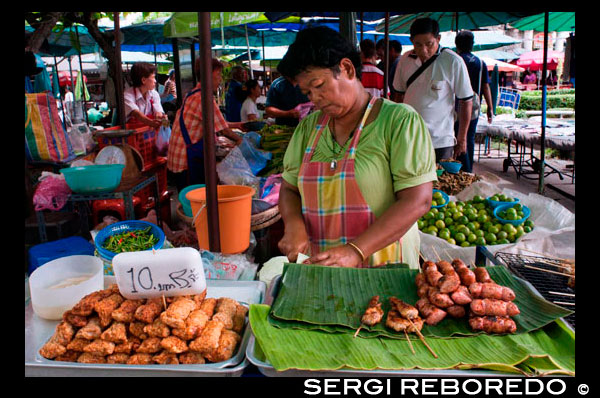 Els llocs de menjar a Tha Chang Pier 9. dona rotllets de primavera venda. Bangkok. Tailàndia. Desenes de Phra Chan Road de llocs tenen pràcticament tots els desitjos d'aliments tailandesos coberts. Si hi ha una regla d'aliments a Tailàndia, és que l'àrea que envolta qualsevol universitat serà una mina d'or gastronòmica. Aquest petit grup dels sou i restaurants al riu al final de Phra Chan Road i al costat de la Universitat de Thammasat és prova més que suficient. En el front, és sobretot botigues de venda de roba i joies, però cap al riu diminuts passadissos i concorreguts restaurants de paret a paret vendre gairebé cada plat tailandès imaginable, i molts dels seients vénen amb una relaxant vista del riu. Més avall Maharat Road - més enllà del mercat amulet - Tha Chang Pier és una altra àrea de la riba densament poblat amb tot tipus de menjar i postres carros. Com arribar-hi: Prendre el ferri Chao Phraya Express per Tha Chang Pier. Millor època per visitar: De dilluns a divendres, durant el dia.