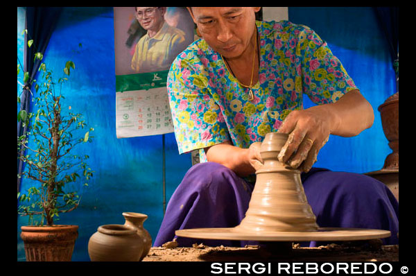 Ko Kred ceramics, Bangkok, Thailand. Potter turning clay vase on potters wheel at a craft workshop in Ko Kred Island near Bangkok Thailand. Ko Kret (also Koh Kred) is an island in the Chao Phraya River, 20 km north of Bangkok, Thailand. The island dates only to 1722, when a canal was constructed as a shortcut to bypass a bend in the Om Kret branch of the Chao Phraya river. As the canal was widened several times, the section cut off eventually became a separate island. The island continues to serve as a refuge to the Mon tribes who dominated central Thailand between the 6th and 10th centuries and have retained a distinct identity in their version of Buddhism and, particularly at Ko. One way to reach Ko Kret is to take the once-weekly Chao Phraya Express, which leaves the Central Pier (BTS Saphan Taksin) every Sunday at 09:00 and visits a number of attractions before returning at 15:30. The cost of the cruise and guided tour is 300 baht (no lunch). Many other companies also offer similar tours, often just as a stop on a longer upriver trip to Ayutthaya. Independent travel to Ko Kret can be a little more challenging. The easiest option is to take public bus 166 from Victory Monument which travels all the way to the market in Pak Kret. From there, you have to walk about 500 metres (or take a moto/samlor) towards the river to the ferry pier, which is located behind Wat Sanam Neua. If you exit the bus before the U-Turn simply continue towards the river. On the left you will see the entrance to a fairly inconspicuous market. Enter this then follow the market as long as you can (i.e. stay with the shops). Eventually you will come out near to the Wat and the route will be very obvious.