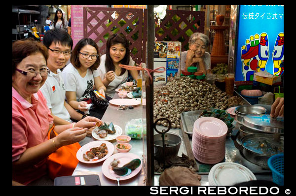 Restaurants in Thanon Yaowarat road at night in central Chinatown district of Bangkok Thailand. Yaowarat and Phahurat is Bangkok's multicultural district, located west of Silom and southeast of Rattanakosin. Yaowarat Road is the home of Bangkok's sizable Chinese community, while those of Indian ethnicity have congregated around Phahurat Road. By day, Yaowarat doesn't look that much different from any other part of Bangkok, though the neighbourhood feels like a big street market and there are some hidden gems waiting to be explored. But at night, the neon signs blazing with Chinese characters are turned on and crowds from the restaurants spill out onto the streets, turning the area into a miniature Hong Kong (minus the skyscrapers). Phahurat is an excellent place for buying fabrics, accessories and religious paraphernalia. A visit to the area is not complete without having some of its amazing delicacies that sell for an absolute bargain — such as bird's nest or some Indian curries. Bangkok’s Chinatown is a popular tourist attraction and a food haven for new generation gourmands who flock here after sunset to explore the vibrant street-side cuisine. At day time, it’s no less busy, as hordes of shoppers descend upon this 1-km strip and adjacent Charoenkrung Road to get a day’s worth of staple, trade gold, or pay a visit to one of the Chinese temples. Packed with market stalls, street-side restaurants and a dense concentration of gold shops, Chinatown is an experience not to miss. The energy that oozes from its endless rows of wooden shop-houses is plain contagious – it will keep you wanting to come back for more. Plan your visit during major festivals, like Chinese New Year, and you will see Bangkok Chinatown at its best. 