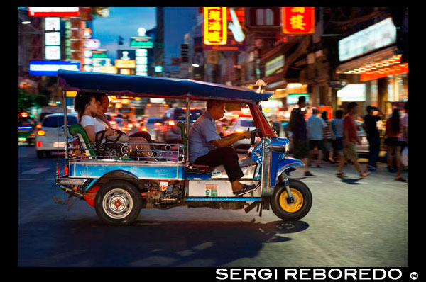 Tuk tuk en la calle. Vea abajo de la carretera Thanon Yaowarat en la noche en el céntrico barrio de Chinatown de Bangkok, Tailandia. Yaowarat y Phahurat es multicultural barrio de Bangkok, situada al oeste de Silom y sureste de Rattanakosin. Yaowarat Road es el hogar de la comunidad china grande de Bangkok, mientras que los de etnia india se han congregado alrededor Phahurat Road. Durante el día, Yaowarat no se ve muy diferente de cualquier otra parte de Bangkok, aunque el barrio se siente como un gran mercado de la calle y hay algunas joyas ocultas esperando a ser explorado. Pero por la noche, los letreros de neón resplandecientes con caracteres chinos están encendidos y las multitudes de los restaurantes se dejan caer por las calles, convirtiendo la zona en una miniatura de Hong Kong (menos los rascacielos). Phahurat es un lugar excelente para la compra de telas, accesorios y objetos religiosos. Una visita a la zona no está completa sin contar con algunos de sus manjares sorprendentes que se venden por una absoluta ganga - como nido de pájaro o algunos curries indios. El barrio chino de Bangkok es una atracción turística popular y un refugio de alimentos para gourmands de nueva generación que se reúnen aquí después del atardecer para explorar la vibrante cocina a pie de calle. A la hora del día, no es menos concurrido, como hordas de compradores descienden sobre esta franja de 1 km y adyacente Charoenkrung camino para obtener valor de un día de primera necesidad, el oro del comercio, o pagar una visita a uno de los templos chinos. Repleto de puestos de mercado, restaurantes callejeros y una densa concentración de tiendas de oro, el barrio chino es una experiencia que no te pierdas. La energía que emana de sus interminables filas de madera casas-tienda es llano contagiosa - que le mantendrá con ganas de volver por más. Planifique su visita durante los grandes festivales, como el Año Nuevo Chino, y verá Bangkok Chinatown en su mejor momento.