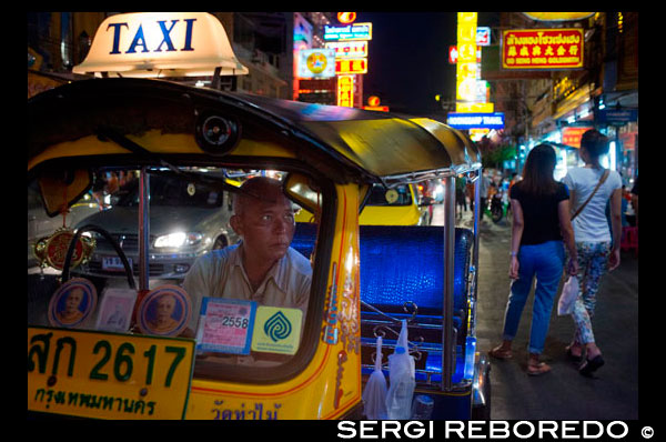 Tuk tuk en la calle. Vea abajo de la carretera Thanon Yaowarat en la noche en el céntrico barrio de Chinatown de Bangkok, Tailandia. Yaowarat y Phahurat es multicultural barrio de Bangkok, situada al oeste de Silom y sureste de Rattanakosin. Yaowarat Road es el hogar de la comunidad china grande de Bangkok, mientras que los de etnia india se han congregado alrededor Phahurat Road. Durante el día, Yaowarat no se ve muy diferente de cualquier otra parte de Bangkok, aunque el barrio se siente como un gran mercado de la calle y hay algunas joyas ocultas esperando a ser explorado. Pero por la noche, los letreros de neón resplandecientes con caracteres chinos están encendidos y las multitudes de los restaurantes se dejan caer por las calles, convirtiendo la zona en una miniatura de Hong Kong (menos los rascacielos). Phahurat es un lugar excelente para la compra de telas, accesorios y objetos religiosos. Una visita a la zona no está completa sin contar con algunos de sus manjares sorprendentes que se venden por una absoluta ganga - como nido de pájaro o algunos curries indios. El barrio chino de Bangkok es una atracción turística popular y un refugio de alimentos para gourmands de nueva generación que se reúnen aquí después del atardecer para explorar la vibrante cocina a pie de calle. A la hora del día, no es menos concurrido, como hordas de compradores descienden sobre esta franja de 1 km y adyacente Charoenkrung camino para obtener valor de un día de primera necesidad, el oro del comercio, o pagar una visita a uno de los templos chinos. Repleto de puestos de mercado, restaurantes callejeros y una densa concentración de tiendas de oro, el barrio chino es una experiencia que no te pierdas. La energía que emana de sus interminables filas de madera casas-tienda es llano contagiosa - que le mantendrá con ganas de volver por más. Planifique su visita durante los grandes festivales, como el Año Nuevo Chino, y verá Bangkok Chinatown en su mejor momento.