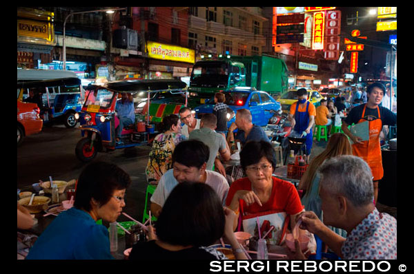 Restaurantes y vida nocturna en la carretera Thanon Yaowarat en la noche en el céntrico barrio de Chinatown de Bangkok, Tailandia. Yaowarat y Phahurat es multicultural barrio de Bangkok, situada al oeste de Silom y sureste de Rattanakosin. Yaowarat Road es el hogar de la comunidad china grande de Bangkok, mientras que los de etnia india se han congregado alrededor Phahurat Road. Durante el día, Yaowarat no se ve muy diferente de cualquier otra parte de Bangkok, aunque el barrio se siente como un gran mercado de la calle y hay algunas joyas ocultas esperando a ser explorado. Pero por la noche, los letreros de neón resplandecientes con caracteres chinos están encendidos y las multitudes de los restaurantes se dejan caer por las calles, convirtiendo la zona en una miniatura de Hong Kong (menos los rascacielos). Phahurat es un lugar excelente para la compra de telas, accesorios y objetos religiosos. Una visita a la zona no está completa sin contar con algunos de sus manjares sorprendentes que se venden por una absoluta ganga - como nido de pájaro o algunos curries indios. El barrio chino de Bangkok es una atracción turística popular y un refugio de alimentos para gourmands de nueva generación que se reúnen aquí después del atardecer para explorar la vibrante cocina a pie de calle. A la hora del día, no es menos concurrido, como hordas de compradores descienden sobre esta franja de 1 km y adyacente Charoenkrung camino para obtener valor de un día de primera necesidad, el oro del comercio, o pagar una visita a uno de los templos chinos. Repleto de puestos de mercado, restaurantes callejeros y una densa concentración de tiendas de oro, el barrio chino es una experiencia que no te pierdas. La energía que emana de sus interminables filas de madera casas-tienda es llano contagiosa - que le mantendrá con ganas de volver por más. Planifique su visita durante los grandes festivales, como el Año Nuevo Chino, y verá Bangkok Chinatown en su mejor momento.