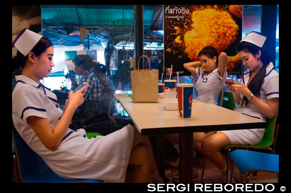 Trabajadores de la clínica niñas bonitas atractivas vestidas como enfermeras comiendo en un Kentucky Fried Chicken. Bangkok. Tailandia. Bangkok; sexy; las niñas; vestido; vestido; enfermera; enfermeras; clínica; trabajar; los trabajadores; comer; comer; restautant; rápido; alimentos; comida rápida; Kentucky Fried Chicken; Kentucky; mesa; Pollo Frito; Tailandia; ciudad; thai; Asia; asiático; pepsi; fresco; adorable; lindo; emocionante; exótico; glamour; rebeldes; iphone; mensaje; que pasa; escribir; writen; sureste; viajar; destinos turísticos; pho; escena; urbano; Rama; central; centro; hermosa; en contacto; cosplay; traje; lindo; destinos; vestido; ojos; moda; femenina; Festival; chica; peinado; sombrero; lente; ubicaciones; modelo; enfermera; Oriente; oriental; jugar; plantear; bella; pelirroja; sexy; estilo; adolescente; thai; Tailandia; viajar; peluca; mujeres; mundo; los jóvenes; cultura; patrimonio; histórico; ubicado; principal; de fusión; vista; importante; el capital; ciudades; durante el día; ubicaciones; sureste; en pie; historia; extraño; calle; estilo; thai; Tailandia; viajar; tendencias; moda; ineludible; urbano; boga; caliente; fin de semana; extraño; rareza; mundo; joven