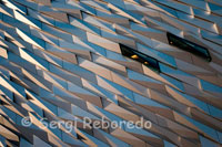 The building is clad in metal shards and when the light plays on them it looks like the movement of water. From above, the building resembles a white star, the symbol of Titanic’s operators. When finished, the visitor attraction will be surrounded by public realm, including reflecting pools and a trail which will take the visitor on a journey through Belfast’s industrial past. Belfast has been slow to tell Titanic’s story from its point of view. It has taken nearly one hundred years for the fate of the “practically unsinkable” ship to be reconciled in the minds of the city which built her. She was sent out with such pride and yet less than two weeks after leaving her home, she was at the bottom of the Atlantic Ocean. While other cities around the world, some with strong Titanic connections and some with no connection at all, have built attractions, Belfast has lagged behind, almost uncertain of what to do with the story. In 2011 and 2012, the city is at a stage where it can celebrate the achievement of engineering which Titanic represents as well as telling some of the unknown stories of the men who built her and sailed on her. 016-CH0381: A giant steel name plate marks the entrance to the Titanic Belfast Experience on March 27, 2012 in Belfast, Northern Ireland. The Titanic Belfast Experience is a new £90 million visitor attraction opening on March 31, 2012. One hundred years ago the maiden voyage of the ill-fated passenger liner Titanic sank after hitting an iceberg in the Atlantic on the night of April 14, 1911 with the loss of 1517 lives. 