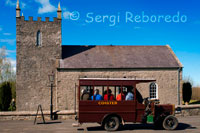 Ulster folk & transport museum. Ballycultra town Buildings. Church of Ireland At the time Kilmore Church was built in 1790, the Church of Ireland was still the Established Church in Ireland, and was supported by tithes.  This 10 per cent payment of the annual produce of land or labour was made to the church by the entire population, whether they belonged to it or not. This small Anglican (Protestant Episcopalian) church was built to accommodate 160 people, although parish records show the usual attendance was about 100 worshippers. An argument raged throughout the Anglican Communion in the 1840s and 1850s over the nature of worship and the use of rituals introduced by the Anglo-Catholic movement.  To heal this rift in the parish, the new rector who was appointed in 1868, built a new church nearby and this building served as a parish hall, a school and a store. In the 1880s it became common for Anglican churches to replace their box pews with rows of open pews. When Kilmore Church was being moved to the Museum, the layout of the original box pews was clearly visible on the floor and it was decided to reinstate the original 18th century interior. Original location: Kilmore, Crossgar, County Down 