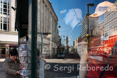 Reflexiones en una ventana de una de las tiendas en el centro de Belfast. Todos los grandes almacenes y cadenas habituales de gama alta se encuentra en High Street y la avenida Real, y las calles más pequeñas que las conectan. Esta zona es sobre todo para los peatones. El centro comercial Castlecourt está situado en la avenida Real y es el más grande de Irlanda del Norte el centro comercial, con más de 70 tiendas diferentes. Las casas de Lisburn Road de centros comerciales boutiques de moda de diseño. Para obtener más individual, tiendas arty, explorar el Barrio de la Catedral, así como Bedford Street, Dublin Road y el paso de Donegall (la mezcla de este último e interesante de tiendas y mercadillos de antigüedades del motorista), donde encontrará interesantes tiendas de diseño, antigüedades, tiendas de regalos y muchos otros pequeños puntos de venta en Belfast. Para las artes y oficios, visite el hombre de mimbre en la Sala de Donegall. En los talleres colectivos (1a calle Lawrence), usted puede recoger pinturas, esculturas, muebles y artesanías directamente del artista. Mercado de San Jorge, el acceso a través de Oxford Street, es la última sobreviviente mercado cubierto de Victoria en Belfast y ha sido restaurado recientemente, dándole un nuevo soplo de vida. Los viernes el mercado de alimentos se ejecuta 07.00 a 15.00 y vende fruta fresca, verduras, flores y peces, así como algunos artículos diversos.