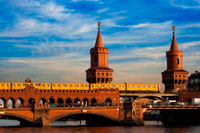 Germany, Berlin, the Oberbaumbrücke bridge that links Kreuzberg and Friedrichshain districts over the Spree river. The Oberbaum Bridge (German: Oberbaumbrücke) is a double-deck bridge crossing Berlin's River Spree, considered one of the city landmarks. It links Friedrichshain and Kreuzberg, former boroughs that were divided by the Berlin Wall, and has become an important symbol of Berlin’s unity. The lower deck of the bridge carries a roadway, which connects Oberbaum Straße to the south of the river with Warschauer Straße to the north. The upper deck of the bridge carries Berlin U-Bahn line U1, between Schlesisches Tor and Warschauer Straße stations.