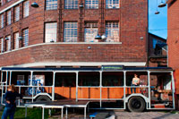 Berlín, Alemania, en un viejo autobús en la Arena de Berlín. Bancos de gran tamaño y coches cubiertos de hierba en el Arena de Berlín. Eventos culturales en un edificio de la fábrica que aparece a lo largo de la antigua frontera de la RDA. Hoy en día, este 7000 lugar m² en el borde del río Spree es el sitio para innumerables conciertos, ferias y fiestas -, pero el complejo de edificios en el distrito de Treptow de Berlín fue originalmente utilizado de manera muy diferente: Diseñado por el arquitecto Franz Ahrens, el estadio fue construido en 1927 como una sala de bus para el sistema de transporte público de Berlín. En ese momento, era la sala más grande de independiente de Europa y podría contener 240 autobuses. Durante el período nazi, se convirtió en un arsenal de armas. Después de que el Muro de Berlín fue construido en 1961, ya no era accesible debido a su ubicación; después de la reunificación alemana, los servicios de transporte público de Berlín cerró oficialmente el edificio por completo.