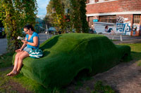 Berlín, Alemania, el Jardín de la desaceleración Arena flota Berlín. Bancos de gran tamaño y coches cubiertos de hierba en el Arena de Berlín. Eventos culturales en un edificio de la fábrica que aparece a lo largo de la antigua frontera de la RDA. Hoy en día, este 7000 lugar m² en el borde del río Spree es el sitio para innumerables conciertos, ferias y fiestas -, pero el complejo de edificios en el distrito de Treptow de Berlín fue originalmente utilizado de manera muy diferente: Diseñado por el arquitecto Franz Ahrens, el estadio fue construido en 1927 como una sala de bus para el sistema de transporte público de Berlín. En ese momento, era la sala más grande de independiente de Europa y podría contener 240 autobuses. Durante el período nazi, se convirtió en un arsenal de armas. Después de que el Muro de Berlín fue construido en 1961, ya no era accesible debido a su ubicación; después de la reunificación alemana, los servicios de transporte público de Berlín cerró oficialmente el edificio por completo.