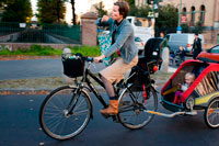 Berlín. Alemania. Una madre lleva a su hijo en bicicleta por las calles de Prenzlauer Berg. Prenzlauer Berg es una localidad de Berlin, que forma la parte sur del barrio de Pankow. Hasta 2001, Prenzlauer Berg era en sí mismo un municipio de Berlin; en ese año fue combinado (junto a la antigua ciudad Weißensee) en el barrio de Pankow. Después de la reunificación alemana en 1990 Prenzlauer Berg se convirtió en un centro para la juventud de Berlín más bohemio, mientras que más recientemente se ha experimentado aburguesamiento.