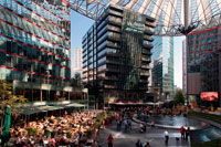 dins de Sony Center a Potsdamer Platz a Berlín . Potsdamer Platz (alemany : [ ? ? ? P tsdam plats ] (escoltar ) , literalment la Plaça de Potsdam ) és una important plaça pública i la intersecció de trànsit al centre de Berlín , Alemanya , situada a 1 km ( 1.100 m ) al sud de la Porta de Brandenburg i el Reichstag ( Edifici del Parlament alemany ) , i prop de la cantonada sud-est del parc Tiergarten . Porta el nom de la ciutat de Potsdam , a uns 25 km ( 16 milles ) a l'oest del sud , i marca el punt on el camí vell de Potsdam passa a través de la muralla de la ciutat de Berlín a la Porta de Potsdam . Després de desenvolupar en l'espai de poc més d'un segle a partir d'una intersecció de vies rurals en la intersecció de trànsit més bulliciosa a Europa , es va posar totalment de residus durant la Segona Guerra Mundial i després va deixar desolat durant l'època de la Guerra Freda , quan el Mur de Berlín dividia la seva antiga ubicació . Des de la reunificació alemanya , la Potsdamer Platz ha estat l'escenari dels grans projectes de reurbanització . Potsdamer Platz va començar com un lloc comercial on diverses carreteres del país es van reunir a les afores de la paret de la duana antiga de Berlín