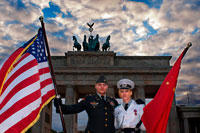 Berlín. Alemania. Actores vestidos de soldados estadounidenses y soviéticos posan para fotos con los turistas delante de la Puerta de Brandenburgo en Berlín, uno de los monumentos más emblemáticos de la Guerra Fría. La Puerta de Brandeburgo es la marca comercial de Berlín. La entrada principal a la ciudad, rodeado por la pared desde hace treinta años, era conocida en todo el mundo como un símbolo de la división de la ciudad y de la división del mundo en dos bloques de poder. Visitantes internacionales de hoy en día a la Pariser Platz vienen a volver a experimentar esta primera puerta de entrada a la ciudad, y disfrutar de la libertad largamente negado a caminar a través de esta magnífica obra de arte y mirarlo de cerca.