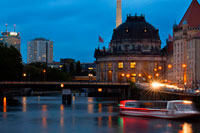 Berliner Dom or Berlin Cathedral at night in central (mitte) Berlin in Germany. The first church Berliner Dom. The first church was built here in 1465. This rather modest building later served as the court church for the Hohenzollern family. The church was replaced by a cathedral, built between 1745 and 1747 in a Baroque design from Johann Boumann. It was remodeled into a classicist building from 1816 to 1822 following a design by the Berlin architect Karl Friedrich Schinkel. The East Side Tour focuses on the best-known sights along the river Spree in the eastern part of Berlin and includes some highlights in the government quarter as well. 