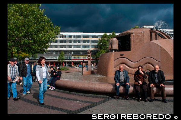 Breitscheidplatz y Europa Center , Berlín , Alemania. Breitscheidplatz encuentra en el distrito de Charlottenburg , cerca del extremo suroeste del parque Tiergarten y el Jardín Zoológico en la esquina de la avenida Kurfürstendamm y el este de la continuación , la Tauentzienstraße , llevando a Schöneberg y la Kaufhaus des Westens en Wittenbergplatz . El centro comercial y de gran altura Europa-Center cierra el Breitscheidplatz al este. En su centro se encuentra la iglesia Kaiser Wilhelm Memorial Day con su aguja dañada. Breitscheidplatz se encuentra al final de la antigua camino de herradura Kurfürstendamm de 1542 que llevó elector ( Kurfürst ) Joachim II Hector de Brandenburgo a sus cotos de caza en el bosque de Grunewald . En 1889 la plaza se le dio el nombre Gutenbergplatz después de Johannes Gutenberg , el diseñador de la imprenta ; en 1892 pasó a llamarse Auguste- Viktoria- Platz, en honor de la emperatriz Augusta Viktoria alemán de Schleswig -Holstein. Poco después de la plaza fue diseñada, el cónyuge de Auguste- Viktoria emperador Wilhelm II determinó como el sitio para la Iglesia Memorial Kaiser Wilhelm en honor a su abuelo, el emperador Guillermo I. La iglesia , diseñada por el arquitecto real Francisco Schwechten , era un buen ejemplo de la arquitectura del renacimiento románico. Fue consagrada en 1895. Alrededor de la plaza hasta la Primera Guerra Mundial , el mayor desarrollo se produjo en un estilo neo-romano similar, incluyendo en el lado oeste del Ausstellungshallen am Zoologischen Garten, una exposición y espacio para eventos, completado en 1896, y frente a ella la 1899 edificio en el sitio de la actual Europa- Center, que después de 1916 albergó la Romanisches Café. La plaza se llama a veces el Foro Romanisches ( foro románica ) o Romanisches Viertel (barrio románica ) como resultado.