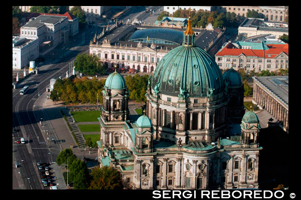 Berlin Cathedral, aerial landscape viewed from the TV tower, Berlin. The Berliner Dom (Berlin Cathedral), completed in 1905, is Berlin’s largest and most important Protestant church as well as the sepulchre of the Prussian Hohenzollern dynasty. This outstanding high-renaissance baroque monument has linked the Hohenzollerns to German Protestantism for centuries and undergone renewed phases of architectural renovation since the Middle Ages. First built in 1465 as a parish church on the Spree River it was only finally completed in 1905 under the last German Kaiser -Wilhelm II. Damaged during the Second World War it remained closed during the GDR years and reopened after restoration in 1993.  The “old” Cathedral at the Lustgarten was initially constructed between 1747 and 1750 under Friedrich the Great (1740-1786) as a baroque church in accordance with Knobersdorff’s plans by Johann Bourmann. From 1817 to 1822 Karl Friedrich Schinkel redesigned it but the Cathedral retained its stylistic similarity to the high-renaissance baroque architecture of St. Peter’s Cathedral in Rome. Finally, official plans reconciling the different stages and stylistic developments were presented by Julius Rashdorff in 1885 to King Friedrich Wilhelm IV. When Wilhelm II ascended the throne in 1888 he authorised the demolition of the “old” Cathedral and the construction, began in 1893, of the much larger, imposing present Berliner Dom.