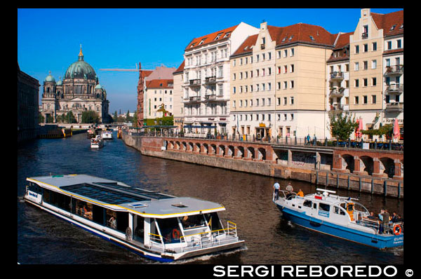 A tourist boat on the Spree river alongside The Nikolaiviertel or St. Nicholas Quarter on a sunny day. Nicholas quarter with the berliner dom or cathedral in the background on a sunny day. The area contained some of the oldest building. The area got its name from the parish church in its centre, dating back to the 13th century. This district is just about the only part of Berlin that has a medieval look to it, with small gabled houses and narrow alleyways. Once the home of artists and writers, the Nicolaiviertel is nowadays filled with tourists visiting the souvenir shops and popular restaurants. Crossing the River Spree, across a view of Nicolaiviertel (Henry: this is pronounced Neeckolayfeertel). In the background, the television tower, a bit like the CN tower. Much of the area was destroyed during the war and the GDR, i.e. communist East Germany only got to its reconstruction between 1979 and 1987. The idea of recreating a medieval village created a lot of controversy. In fact, with only a few exceptions, the 'medieval' houses in the district are newly built replicas of historic buildings. And even some of the authentic ones had to be restored and were moved here from various other locations.  Nevertheless, the area is charming and we had a very pleasant walk there. once we crossed the river, we had a look at the outside of the Ephraim Palace, once called the most beautiful corner of Berlin. It is a very ornate, Baroque palace built in 1766 for Nathan Ephraim, Frederick the Great's mint master and court jeweler. In 1935, the palace was demolished, when the bridge next to it was being widened, but most of the façade was saved and stored and in 1983 the building was restored. Today, the palace houses various temporary exhibitions. As for us, we decided to just have. Look at its exterior and walk on along the river. 