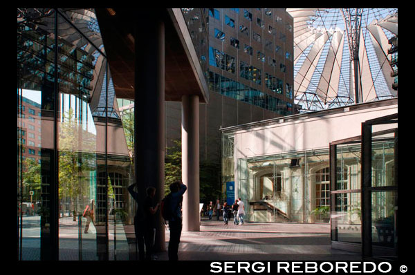 dins de Sony Center a Potsdamer Platz a Berlín . Potsdamer Platz (alemany : [ ? ? ? P tsdam plats ] (escoltar ) , literalment la Plaça de Potsdam ) és una important plaça pública i la intersecció de trànsit al centre de Berlín , Alemanya , situada a 1 km ( 1.100 m ) al sud de la Porta de Brandenburg i el Reichstag ( Edifici del Parlament alemany ) , i prop de la cantonada sud-est del parc Tiergarten . Porta el nom de la ciutat de Potsdam , a uns 25 km ( 16 milles ) a l'oest del sud , i marca el punt on el camí vell de Potsdam passa a través de la muralla de la ciutat de Berlín a la Porta de Potsdam . Després de desenvolupar en l'espai de poc més d'un segle a partir d'una intersecció de vies rurals en la intersecció de trànsit més bulliciosa a Europa , es va posar totalment de residus durant la Segona Guerra Mundial i després va deixar desolat durant l'època de la Guerra Freda , quan el Mur de Berlín dividia la seva antiga ubicació . Des de la reunificació alemanya , la Potsdamer Platz ha estat l'escenari dels grans projectes de reurbanització . Potsdamer Platz va començar com un lloc comercial on diverses carreteres del país es van reunir a les afores de la paret de la duana antiga de Berlín . La història de la Potsdamer Platz , probablement es remunta al 29 d'octubre de 1685, quan es va signar l'Edicte de Tolerància de Potsdam , en què Frederic Guillem , elector de Brandenburg - Prússia 1640-1688 , va permetre que un gran nombre de refugiats religiosos , incloent Jueus d'Àustria i hugonots expulsats de França , a establir-se en el seu territori . Una motivació clau darrere de l'Edicte era el que l'elector podria encoratjar la ràpida repoblació , restabilising i la recuperació econòmica del seu regne , arran dels estralls de la Guerra dels Trenta Anys ( 1618-1648) . En total , fins a 15.000 hugonots van fer noves llars a la regió de Brandenburg , uns 6.000 d'ells a la capital , Berlín ( de fet, en 1700 i durant un temps després , fins a un 20% de la població de Berlín era de parla francesa ) . Dues coses van resultar d'aquesta gran afluència . En primer lloc , fortificacions medievals de Berlín , recentment reconstruït 1658-1674 en la forma d'una estrella d'estil holandès forta, a una escala enorme i amb grans despeses ( i similar als exemples encara en existent avui dia als Països Baixos com Naarden i Bourtange ) , es va convertir en durant la nit pràcticament redundant ; i de segona