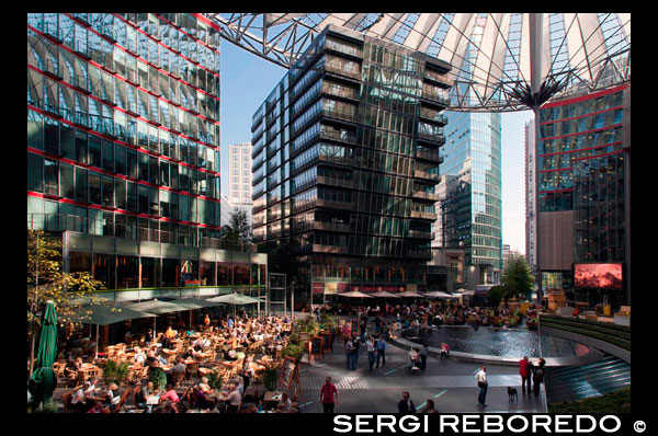 dins de Sony Center a Potsdamer Platz a Berlín . Potsdamer Platz (alemany : [ ? ? ? P tsdam plats ] (escoltar ) , literalment la Plaça de Potsdam ) és una important plaça pública i la intersecció de trànsit al centre de Berlín , Alemanya , situada a 1 km ( 1.100 m ) al sud de la Porta de Brandenburg i el Reichstag ( Edifici del Parlament alemany ) , i prop de la cantonada sud-est del parc Tiergarten . Porta el nom de la ciutat de Potsdam , a uns 25 km ( 16 milles ) a l'oest del sud , i marca el punt on el camí vell de Potsdam passa a través de la muralla de la ciutat de Berlín a la Porta de Potsdam . Després de desenvolupar en l'espai de poc més d'un segle a partir d'una intersecció de vies rurals en la intersecció de trànsit més bulliciosa a Europa , es va posar totalment de residus durant la Segona Guerra Mundial i després va deixar desolat durant l'època de la Guerra Freda , quan el Mur de Berlín dividia la seva antiga ubicació . Des de la reunificació alemanya , la Potsdamer Platz ha estat l'escenari dels grans projectes de reurbanització . Potsdamer Platz va començar com un lloc comercial on diverses carreteres del país es van reunir a les afores de la paret de la duana antiga de Berlín . La història de la Potsdamer Platz , probablement es remunta al 29 d'octubre de 1685, quan es va signar l'Edicte de Tolerància de Potsdam , en què Frederic Guillem , elector de Brandenburg - Prússia 1640-1688 , va permetre que un gran nombre de refugiats religiosos , incloent Jueus d'Àustria i hugonots expulsats de França , a establir-se en el seu territori . Una motivació clau darrere de l'Edicte era el que l'elector podria encoratjar la ràpida repoblació , restabilising i la recuperació econòmica del seu regne , arran dels estralls de la Guerra dels Trenta Anys ( 1618-1648) . En total , fins a 15.000 hugonots van fer noves llars a la regió de Brandenburg , uns 6.000 d'ells a la capital , Berlín ( de fet, en 1700 i durant un temps després , fins a un 20% de la població de Berlín era de parla francesa ) . Dues coses van resultar d'aquesta gran afluència . En primer lloc , fortificacions medievals de Berlín , recentment reconstruït 1658-1674 en la forma d'una estrella d'estil holandès forta, a una escala enorme i amb grans despeses ( i similar als exemples encara en existent avui dia als Països Baixos com Naarden i Bourtange ) , es va convertir en durant la nit pràcticament redundant ; i de segona