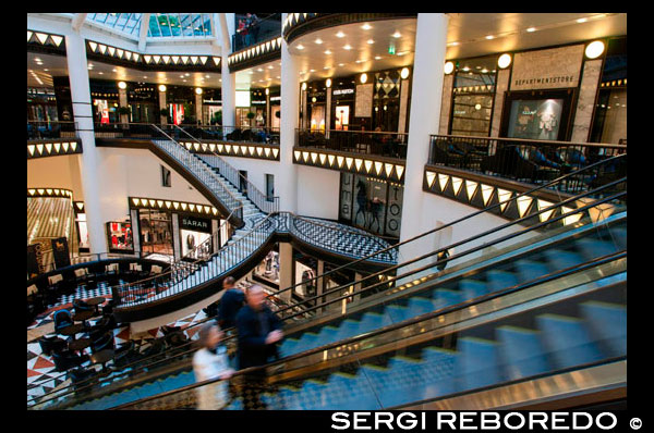 Quartier 205 , centro comercial de lujo en Berlín. Friedrichstrasse es una de las calles más legendarios de toda la ciudad , que combina la tradición de la " dorados años veinte " con la arquitectura de Berlín allá de 1989 . En los años 20 , los 3,5 km de largo de la calle era el lugar para estar con los cafés, teatros y vodeviles , como el famoso Wintergarten . Para 1997 Friedrichstraße era todavía un sitio poco atractivo edificio en la parte este de Berlín. Los comerciantes de la " City West ' estaban en contra del desarrollo de este. Al igual que en la política de las bandas de West -Side- Story , este vs West historia oriental se enfrentaron hasta que un inversor alemán sorprendentemente construyó un centro comercial de lujo en este lugar histórico . El edificio , Quartier 206 , creado por el arquitecto con sede en Nueva York , IM Pei, fue diferente , repugnante para los de la vieja escuela - berlineses y (casi) imposible alquilar en el momento . Ahora Friedrichstrasse 71 cuenta con un extravagante estilo Art Déco y es el hogar de las boutiques de los mejores diseñadores incontables , que ofrece más de 8.000 metros cuadrados de espacio comercial lleno de Mono- Marca - Tiendas como Gucci, Cerruti , La Perla , Akkesoir , Louis Vuitton, Bottega Veneta, Brille 54 , y más. Quartier 205 , 206 y 207 Friedrichstrasse 71 , 10117 Berlín, de lunes a viernes : 10:30 AM- 7 : 30PM , Sab : 10am- 6 pm para una experiencia de compra exclusiva en Mitte probar el Friedrichrichstadt Passagen y su centro comercial ' Quartiers ' , que es a tres cuadras de la compra lleno de tiendas de diseñadores maravillosos , unidos únicamente por pasadizos subterráneos. Usted se sentirá como si usted está entrando en las páginas de una revista de moda de gama alta en uno de los más bellos lugares de Art Deco en Berlín. Quartier 206 es muy extravagante, y la élite de la moda internacional son completamente como en casa en sus salones individuales. Gucci, Yves Saint Laurent, Etro , Moschino , Vuitton, Cerruti y Bottega Veneta están aquí , ya que es impresionante de tiendas por departamento de Ana Maria Jagdfeld . El emporio francés Galeries Lafayette, en el Quartier 207 , es conocida por su imponente cono de vidrio luminoso en la entrada, y por supuesto, muchas más tiendas abundan , incluyendo abundantes especialidades internacionales. Quartier 205 ofertas aún más tiendas y una variedad de opciones de café.