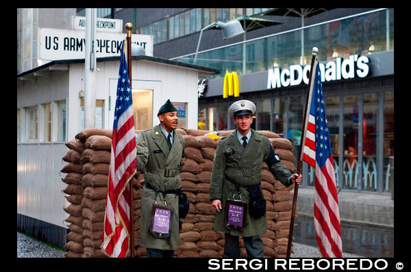 Berlin guerra fría Checkpoint Charlie Friedrichstrasse frontera notorio cruzando sectores soviéticos americanos pared oeste al este . Checkpoint Charlie fue el nombre dado por los aliados occidentales a un punto de cruce entre Berlín Oriental y Berlín Occidental durante la Guerra Fría. Otros puntos de control de los Aliados sobre la autopista hacia el oeste fueron Checkpoint Alfa en Helmstedt y Checkpoint Bravo en Dreilinden , al sureste de Wannsee , llamada del alfabeto fonético de la Organización del Tratado del Atlántico Norte. Muchos otros puntos de cruce sector existían en Berlín. Algunos de ellos fueron designados para los residentes de Berlín Occidental y ciudadanos de Alemania Occidental . Checkpoint Charlie fue designado como el punto de cruce simple ( a pie o en coche) para los extranjeros y los miembros de las fuerzas aliadas. ( Los miembros de las fuerzas aliadas no se les permitía usar el otro punto de cruce sector designado para su uso por parte de extranjeros , la estación de tren de Friedrichstrasse . ) Checkpoint Charlie se encuentra en el cruce de Friedrichstrasse con Zimmerstraße y Mauerstraße ( que casualmente significa ' Wall Street ' ) en el barrio de Friedrichstadt , que fue dividida por el Muro de Berlín . Los soviéticos simplemente lo llamaron el paso fronterizo de Friedrichstrasse [ cita requerida ] . Checkpoint Charlie se convirtió en un símbolo de la Guerra Fría , lo que supone la separación de Oriente y Occidente, y - para algunos alemanes del Este - una puerta a la libertad. Que aparece con frecuencia en películas y libros de espías, como los de John le Carré . La famosa cafetería y mirador para los funcionarios aliados , las Fuerzas Armadas y visitantes por igual , Café Adler ( " Cafe Eagle" ) , está situado justo en el punto de control . Fue un excelente mirador para mirar en Berlín del Este, mientras que tener algo para comer y beber. checkpoint era curiosamente asimétrica. Durante su vida activa de 27 años , la infraestructura en el lado oriental se amplió para incluir no sólo la pared , torre de vigilancia y barreras en zig -zag , pero un multi- carril de una nave en que se revisaron los automóviles y sus ocupantes.