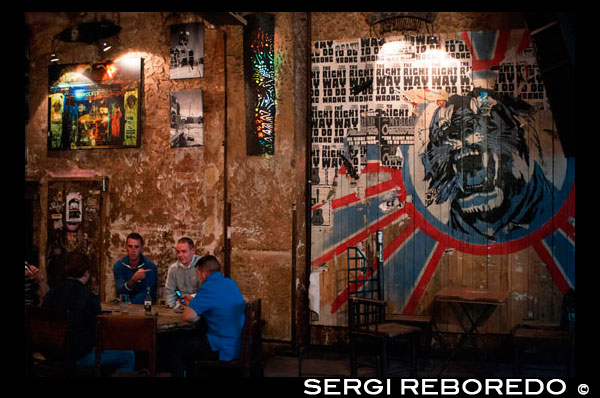 Berlin, Germany, a two-man take a beer in Zapata the Kunsthaus Tacheles. The Kunsthaus Tacheles (Art House Tacheles) was an art center in Berlin, Germany, a large (9000 square meter) building and sculpture park on Oranienburger Straße in the district known as Mitte. Huge, colorful graffiti-style murals are painted on the exterior walls, and modern art sculptures are featured inside. The building houses an artists collective which is threatened with eviction. Originally called "Friedrichsstadtpassagen", it was built as a department store in the Jewish quarter (Scheunenviertel) of Berlin, next to the synagogue. Serving as a Nazi prison for a short while, it was later partially demolished. After the Berlin Wall had come down, it was taken over by artists, who called it Tacheles, Yiddish for "straight talking." The building contained studios and workshops, a nightclub, and a cinema. Outside, the garden featured an open air exhibition of metal sculptures as well as galleries and studios for sculptors and painters. A part of the garden still remains open to the public. The house was finally closed on September 4, 2012. Tacheles Metallwerkstatt, the sculpture park, was open until March 2013, when the finantial group Nordbank decided to make money out of it. A developer called the Fundus Group bought the site from the Berlin government in the mid-1990s. Because it was in no hurry to do anything with the building, it gave the artists a 10-year lease in 1998 at a nominal rent of 50 cents. This contract was then extended but expired at the end of 2009, at which point the artists again became squatters. By this time, the Fundus Group had become insolvent, so the Hamburg-based HSH Nordbank, to which the Fundus Group owed money, decided to sell the property.