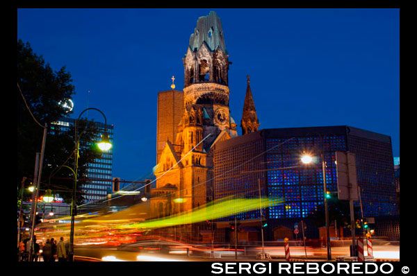 Alemanya, Berlín , Església commemorativa de Kaiser Wilhelm en el crepuscle . El Kaiser Wilhelm Memorial Church protestant ( en alemany : [ ? ? ? ? ? ? ? ? ? D CTN s k c ] Kaiser - Wilhelm - Gedächtniskirche , però més que gens coneguda com Gedächtniskirche ) es troba a Berlín al carrer Kurfürstendamm , al centre de la Breitscheidplatz . L'església original en el lloc va ser construït en la dècada de 1890 . Va ser greument danyada en un bombardeig el 1943. L'edifici actual , que consisteix en una església amb un hall d'entrada adjunt i un campanar independent amb una capella adjunta , va ser construït entre 1959 i 1963 . L'agulla danyada de l'antiga església s'ha mantingut i la seva planta baixa s'ha convertit en un museu commemoratiu . L'Església Memorial d'avui és un símbol de la ciutat de Berlín occidental . Dins de l'església, enfront de l'entrada , és una figura de Crist que està suspesa sobre l'altar . Això es fa de tombak i va ser dissenyada per Karl Hemmeter . La creu en l'altar , per Peter Tauchnitz , és de plata daurada amb 37 cristalls de roca. A l'esquerra de l'altar es troba la pila baptismal en un estand ple de marbre de Carrara , que conté un plat de majòlica per a l'aigua beneïda . A la dreta de l'altar és un púlpit octogonal . Davant l'altar en una galeria és un òrgan que conté prop de 5.000 tubs , que va ser construït per Schuke . Panells de plexiglàs s'han instal · lat més de la galeria d'òrgans per millorar l'acústica . Al costat de la paret nord-est de l'església són tres obres d'art. La primera és una placa de bronze que commemora als màrtirs protestants que van morir durant el règim nazi entre 1933 i 1945 . Incorpora un crucifix de fusta espanyola que data del segle 13 . La placa va ser col · locada a l'església el 20 de juliol de 1964, el 20 aniversari d'un intent d'assassinar a Hitler . Al costat d'això és el de Stalingrad Madonna , en un símbol d'esperança i reconciliació . Es tracta d'un dibuix al carbonet realitzats per Kurt Reuber durant el temps que estava atrapat fora de Stalingrad el Nadal de 1942 . Còpies d'aquest dibuix s'han enviat a la catedral de Coventry i l'Església ortodoxa russa a Stalingrad ( avui Volgograd) . El tercer element de l'art és una icona de la Mare de Déu de Volgograd