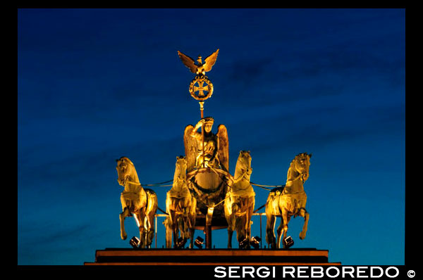 Cuadriga en la puerta de Brandenburgo en la noche , Berlín , Alemania. La Puerta de Brandenburgo (alemán: Brandenburger Tor) es una antigua puerta de la ciudad , reconstruida en el siglo 18 como un arco de triunfo neoclásico , y ahora uno de los hitos más conocidos de Alemania . Se encuentra en la parte occidental del centro de la ciudad de Berlín, en el cruce de la avenida Unter den Linden y Ebertstraße , inmediatamente al oeste de la Pariser Platz. A una cuadra hacia el norte se encuentra el edificio del Reichstag . La puerta es la entrada monumental de la avenida Unter den Linden, el famoso bulevar de tilos , que anteriormente condujo directamente a la ciudad palacio de los reyes de Prusia . Fue encargado por el rey Federico Guillermo II de Prusia como un signo de la paz y construido por Carl Gotthard Langhans 1788-1791 . Después de haber sufrido daños considerables en la Segunda Guerra Mundial, la Puerta de Brandenburgo fue restaurada completamente 2000-2002 por la Stiftung Denkmalschutz Berlín (Fundación de Berlín Monumento Conservación ) . Durante la partición de la posguerra de Alemania, la puerta era aislado e inaccesible inmediatamente al lado del muro de Berlín , y el área alrededor de la puerta apareció más prominente en la cobertura mediática de la apertura del muro en 1989 . A lo largo de su existencia, la Brandenburg Puerta a menudo era un sitio para los grandes acontecimientos históricos y hoy se considera un símbolo de la tumultuosa historia de Europa y Alemania, pero también de la unidad europea y la paz.