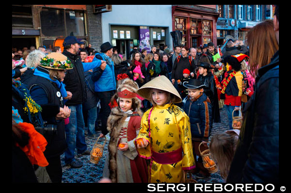 Children and teenagers dressed with costumes. Music, dance, party and costumes in Binche Carnival. Ancient and representative cultural event of Wallonia, Belgium. The carnival of Binche is an event that takes place each year in the Belgian town of Binche during the Sunday, Monday, and Tuesday preceding Ash Wednesday. The carnival is the best known of several that take place in Belgium at the same time and has been proclaimed as a Masterpiece of the Oral and Intangible Heritage of Humanity listed by UNESCO. Its history dates back to approximately the 14th century. Events related to the carnival begin up to seven weeks prior to the primary celebrations. Street performances and public displays traditionally occur on the Sundays approaching Ash Wednesday, consisting of prescribed musical acts, dancing, and marching. Large numbers of Binche's inhabitants spend the Sunday directly prior to Ash Wednesday in costume. The centrepiece of the carnival's proceedings are clown-like performers known as Gilles. Appearing, for the most part, on Shrove Tuesday, the Gilles are characterised by their vibrant dress, wax masks and wooden footwear. They number up to 1,000 at any given time, range in age from 3 to 60 years old, and are customarily male. The honour of being a Gille at the carnival is something that is aspired to by local men