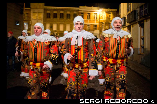 Bèlgica, el carnaval de Binche. Desfilada Festival Mundial de la UNESCO Patrimoni. Bèlgica, Valònia Municipi, província d'Hainaut, poble de Binche. El carnaval de Binche és un esdeveniment que té lloc cada any a la ciutat belga de Binche durant el diumenge, dilluns i dimarts previs al Dimecres de Cendra. El carnaval és el més conegut dels diversos que té lloc a Bèlgica, a la vegada i s'ha proclamat, com a Obra Mestra del Patrimoni Oral i Immaterial de la Humanitat declarat per la UNESCO. La seva història es remunta a aproximadament el segle 14. Esdeveniments relacionats amb el carnaval comencen fins set setmanes abans de les celebracions principals. Espectacles de carrer i exhibicions públiques es produeixen tradicionalment en els diumenges s'acosta al Dimecres de Cendra, que consisteix en actes prescrits musicals, danses i marxes. Un gran nombre d'habitants de Binche passen el diumenge directament abans del Dimecres de Cendra en el vestit. La peça central dels treballs del carnaval són executants de pallasso conegut com Gilles. Apareixent, en la seva major part, el dimarts de Carnaval, el Gilles es caracteritzen per les seves vestit vibrant, màscares de cera i calçat de fusta. El seu nombre és fins a 1000 en un moment donat, el rang d'edats entre 3 i 60 anys d'edat, i són habitualment masculí. L'honor de ser una Gille al carnaval és una cosa que s'aspira per homes locals