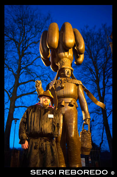 Unusual statue in the grounds of the Collegiate church Saint Ursmer, Binche, Hainaut, Wallonia, Belgium. The carnival of Binche is an event that takes place each year in the Belgian town of Binche during the Sunday, Monday, and Tuesday preceding Ash Wednesday. The carnival is the best known of several that take place in Belgium at the same time and has been proclaimed as a Masterpiece of the Oral and Intangible Heritage of Humanity listed by UNESCO. Its history dates back to approximately the 14th century. Events related to the carnival begin up to seven weeks prior to the primary celebrations. Street performances and public displays traditionally occur on the Sundays approaching Ash Wednesday, consisting of prescribed musical acts, dancing, and marching. Large numbers of Binche's inhabitants spend the Sunday directly prior to Ash Wednesday in costume. The centrepiece of the carnival's proceedings are clown-like performers known as Gilles. Appearing, for the most part, on Shrove Tuesday, the Gilles are characterised by their vibrant dress, wax masks and wooden footwear. They number up to 1,000 at any given time, range in age from 3 to 60 years old, and are customarily male. The honour of being a Gille at the carnival is something that is aspired to by local men