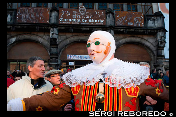 Binche City Hall. The carnival of Binche is an event that takes place each year in the Belgian town of Binche during the Sunday, Monday, and Tuesday preceding Ash Wednesday. The carnival is the best known of several that take place in Belgium at the same time and has been proclaimed as a Masterpiece of the Oral and Intangible Heritage of Humanity listed by UNESCO. Its history dates back to approximately the 14th century. Events related to the carnival begin up to seven weeks prior to the primary celebrations. Street performances and public displays traditionally occur on the Sundays approaching Ash Wednesday, consisting of prescribed musical acts, dancing, and marching. Large numbers of Binche's inhabitants spend the Sunday directly prior to Ash Wednesday in costume. The centrepiece of the carnival's proceedings are clown-like performers known as Gilles. Appearing, for the most part, on Shrove Tuesday, the Gilles are characterised by their vibrant dress, wax masks and wooden footwear. They number up to 1,000 at any given time, range in age from 3 to 60 years old, and are customarily male. The honour of being a Gille at the carnival is something that is aspired to by local men