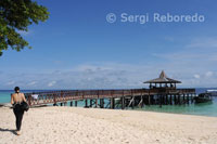 Una buceadora en la playa de la isla de Pualu Mabul junto al cercano hotel Sipadan Water Village Resort. Los arrecifes alrededor de Mabul tienen una mucha reputación por su gran bio-diversidad. Uno de sus mejores lugares de buceo es la Pared de Langostas. 