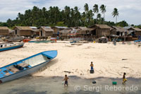 Isla de Pualu Mabul. Varios niños se divierten pescando junto a la orilla ubicada en el poblado de pescadores. Mabul es un minusculo pueblo de pescadores que habitan en casas de madera construidas directamente con pilares sobre el arrecife, a modo de palafitos, unidos entre si a traves de unas pasarelas de madera por las que discurre la vida de la gente, con sus tiendas, escuela...