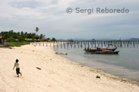 Pualu Mabul. Children walking on the sand near the fishermen's huts. Sabah.