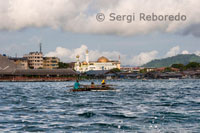 A fishing boat leaving the port of Semporna. In the distance you can see the mosque in Semporna. The only interesting building in Semporna is the mosque, pure white, contrasting with its surroundings, particularly with the market, medium built over the water.