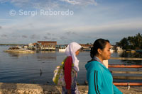 Two local women walk along the pier of Semporna.