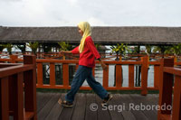 Una adolescente camina sobre las pasarelas del Hotel Dragon Inn en Semporna, lugar plagado de agencias de Submarinismo, como Squba Junkie. 