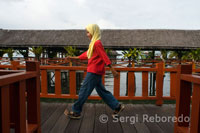 A teenage girl walking on the catwalks of Hotel Dragon Inn in Semporna, a place full of diving agencies, such as sQuba Junkie.