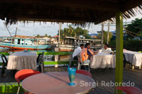 Las mesas junto al mar en uno de los restaurantes de Semporna. Los barcos de pesca del puerto pueden verse atracados en el puerto en la parte posterior de la fotografía.