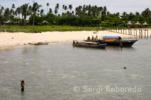 Un niño juega en la orilla del mar junto al poblado de gitanos pescadores en la isla de Pulau Mabul. Barracuda Point. Es el punto de buceo más representativo de Sipadan. Formado por una amplia plataforma coralina, que se extiende en forma de cabo, para repentinamente transformarse en una pared oceánica que desciende hasta casi 1.000 metros. Especialmente a primera hora de la mañana y mejor con corriente, es posible ver un autentico desfile de animales. Para los más madrugadores es casi seguro encontrar un compacto cardumen de peces loro búfalos, frecuentes también son los grupos de peces murciélago y cardúmenes de júreles de ojo grande, pero sin duda alguna lo más esperado son las barracudas, que llegan a formar un cardumen de más de mil ejemplares, que llega a tapar la luz del sol. Entre unos y otros, tiburones grises, puntas plateadas, puntas blancas, algún leopardo y como no podía faltar, tortugas y mas tortugas. Los cientos de peces de arrecife, gorgonias y esponjas realmente quedan eclipsados por todo lo anterior. 