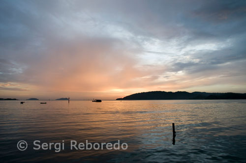 El sol s'amaga en Semporna. Imatge presa des de l'Hotel Dragon Inn. Una antiga plataforma petroliera ha estat convertida en un hotel de bussejadors que és tot un èxit. Se situa en el Mar de Cèlebes, a la part occidental del Pacífic, en una zona que està delimitada per l'illa de Borneo, Indonèsia i les Filipines. És que la vida submarina és tan rica en aquesta zona que és un èxit que no para de créixer entre els aficionats al busseig. Els esculls de corals, els bancs de peixos tropicals, les tortugues marítimes, barracudes i taurons (d'una espècie que no ataca humans). Tot és tan abundant i variat sota aquestes aigües que són molts els interessats en allotjar-se en aquesta plataforma. A les rodalies es troba l'illa de Sipadan, ja coneguda pels bussejadors de tot el món. Com des de l'any passat és un parc nacional, s'expedeixen només 120 permisos de busseig al dia per arribar a la illa, que es reparteixen entre els resorts com el Seaventures.