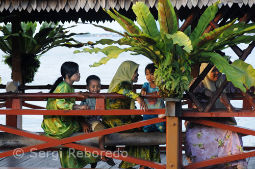 Una familia malaya en una de las pasarelas del Hotel Dragon Inn. Semporna. Este de Sabah. Este es el lugar ideal para los que quieren bucear en Sipadan, ya que este complejo se encuentra en la isla de Sipadan frente al famoso "Drop Of".Esta zona de buceo internacionalmente famosa por sus fondos marinos y su fauna y sus pelágicos (barracudas, tiburones, pez martillo, millones de peces tecnicolores, tortugas, etc... Nuestro programa incluye el avión hasta la ciudad de Kota Kinabalu a la cual se llega el día siguiente de la salida desde España, una noche en el hotel Hyatt Regency o similar, al día siguiente vuelo hasta Tawau al sur de la península de Borneo y desde esta ciudad por tierra hasta el pueblo pesquero de Semporna (70 minutos) y por barco hasta la isla de Sipadan (50 minutos). Oncle Chang lleva a la gente ilegalmente a Sipadam y está borracho todo el día. 