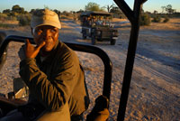 Uno de los guías del Savute Elephant Camp de Orient Express en Botswana, en el Parque Nacional de Chobe. subido a uno de los vehículos 4x4 en el momento de hacer un safari.  Situada en el centro de África Meridional, Botswana, sin acceso al mar, se extiende unos 1.100 km de Norte a Sur y 960 km de Este a Oeste, ocupando un área equivalente a la de Francia, algo mayor que España. Al Sur limita con Suráfrica, a través de los ríos Limpopo y Molopo; al Noreste, con Zimbabue, mientras que Namibia abraza las fronteras oeste y norte. En Kazungula, en el remoto Norte, cuatro países -Botsuana, Zimbabue, Zambia y Namibia- confluyen en el centro de la corriente del río Zambeze. La mayor parte del territorio (un 75%) está en el Kalahari, el desierto más meridional de África aunque no es propiamente un desierto, ya que está cubierto de hierbas y arbustos, pero no hay cursos de agua en su superficie si exceptuamos el río Boteti, lo que le convierte en una tierra no apta para la agricultura o la ganadería y le ha valido el apodo de tierra de la sed. Una meseta de unos 1.200 metros de altitud divide al país en dos regiones, cada una con su propio sistema hidrográfico. En el Norte se encuentran las cuencas pantanosas del Makgarikgari y del Okavango. Una gran extensión de sabanas, donde se desarrollan la ganadería y la agricultura (principales actividades económicas del país), marca la transición de las estepas desérticas del SO y los bosques del N y el NE. Los ríos más importantes son el Okavango, el Limpopo y el Chobé. Entre los lagos, el Ngami y el Xau. Botsuana está considerada como una de las reservas de la flora y fauna africana más importantes del continente. 