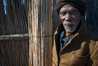 Retrato de abuelo en el campamento Batawana. En las inmediaciones del campamento Eagle Island Camp de Orient Express, en las afueras de la Reserva de Animales de Moremi, en Botswana hay un campamento donde residen un centenar de indígenas de la tribu Batawana. Es posible realizar excursiones en canoa para visitar su poblado. La República de Botswana es un país sin litoral al sur de África, con un tamaño aproximado al de Francia. Tiene una población de unos 1.9 millones de habitantes, la mayoría de los cuales vive en el este, la zona más fértil del país. El idioma oficial y la cultura predominante es la Setswana, perteneciente al pueblo conocido como Batawana. Hay también muchas tribus San en la región del desierto. Botsuana tiene tradición democrática – el sistema kgotla, arraigado en la cultura Setswana basado en un sistema de democracia y libertad de expresión donde todas las personas tienen el derecho a decir lo que piensan. Anteriormente era el protectorado británico de Bechuanaland, adoptando el nuevo nombre de Botsuana al declararse independiente formando parte de la Commonwealth el 30 de septiembre de 1966. Limita con Sudáfrica por el sur y el sureste, con Namibia por el norte y el oeste y con Zimbabue por el noreste. Se encuentra con Zambia en un único punto. Botsuana es conocida por su estabilidad política, sus gentes amables y compasivas, y sus diamantes. Es el mayor exportador de diamantes del mundo. El país es predominantemente llano, y además del delta y las zonas desérticas cuenta con praderas y sabanas. Las sabanas albergan ñúes, gran cantidad de antílopes, y otros mamíferos y aves. Gran parte del país está ocupado por el desierto del Kalahari, lo que hace del agua un valioso bien. 