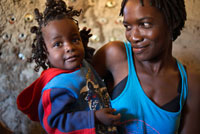 Retrato de una madre vestida occidental con su hija peinada con trenzas en el campamento Batawana. En las inmediaciones del campamento Eagle Island Camp de Orient Express, en las afueras de la Reserva de Animales de Moremi, en Botswana hay un campamento donde residen un centenar de indígenas de la tribu Batawana. Es posible realizar excursiones en canoa para visitar su poblado.  Entre 1978 y 1988, Botswana se transformó en el tercer mayor productor de diamantes del mundo, después de Australia y la actual República Democrática del Congo (entonces, Zaire), y la economía del país creció a un ritmo récord de 12% al año. De todos modos, tres quintas partes de la población vivía de cultivos de subsistencia o actividades «no institucionalizadas», es decir, fuera de las estadísticas, del control fiscal y del mercado comercial. En 1985, hubo repetidas escaramuzas en la frontera con Sudáfrica por el apoyo que el gobierno de Botswana prestó a la lucha del Congreso Nacional Africano (ANC) contra el apartheid. En 1987 Sudáfrica presionó bloqueando las rutas que la unen con Gaborone, la capital de Botswana. Masire fue reelecto en 1989, y el gobierno enfrentó sucesivos problemas económicos y políticos, más que nada, por la merma en la demanda internacional de diamantes. La corrupción gubernamental se hizo evidente y renunciaron varios ministros de Estado. En 1991, tres de los siete partidos opositores crearon el Frente Progresista del Pueblo (FPP) para oponerse al BDP; ese año, el país sufrió las huelgas más importantes desde su independencia. Los trabajadores públicos reclamaron un aumento del 154% y fueron despedidos 18 mil funcionarios estatales. En 1992, el desempleo llegó al 25%. Tratando de aumentar la ocupación y para elevar el alicaído prestigio del BDP, el gobierno incentivó la instalación de industrias ajenas a la minería. Una fuerte sequía obligó a las autoridades a decretar el estado de emergencia; se redujeron drásticamente los gastos públicos y cesó más de un tercio de la mano de obra empleada directa o indirectamente por el Estado. A pesar de los problemas económicos y sociales, el BDP conservó la mayoría en las elecciones legislativas de 1994, perdiendo nueve escaños. 