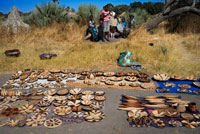 Improvisat mercat d'artesania a l'arribada dels turistes al campament Batawana. En els voltants del campament Eagle Island Camp d'Orient Express, als afores de la Reserva d'Animals de Moremi, a Botswana hi ha un campament on resideixen un centenar d'indígenes de la tribu Batawana. És possible realitzar excursions en canoa per visitar el seu poblat. L'Artesania de la terracota en el Districte de Kgatleng de Botswana va ser declarada Patrimoni cultural immaterial de la Humanitat el 2012 per la UNESCO.1 Es tracta de l'artesania creada per les dones de la comunitat bakgatla va kgafela del Districte de Kgatleng, al sud-est del país. S'utilitza terra argilosa, arenosa erosionada, òxid de ferro, tifes de vaga, aigua, herba i fusta per fabricar recipients en què es plasmen motius de rituals i creences ancestrals de la comunitat. La recol · lecció de la terra es fa a través de la meditació de la mestra artesana. Un cop recol · lectades l'argila i l'arenisca, es piquen i es cribren. Després d'això es forma la pasta per modelar. Després decorar, es couen en un forn de pou. La tradició es va transmetent de generació en generació però actualment aquest art corre perill de desaparició a causa de la disminució del nombre de mestres artesanes, els baixos preus dels productes acabats i l'ús, cada vegada més, de recipients de producció de massa. És per això que la UNESCO el va incloure en la Llista del Patrimoni Cultural Immaterial que requereix mesures urgents de salvaguarda.