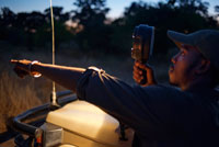 El guia està proveït d'una llanterna de gran potència amb la que busca els animals durant el safari nocturn que Orient Express efectua al campament Khwai River Lodge d'Orient Express a Botswana, a l'interior de la Reserva Salvatge de Caça Moremi, Botswana. Botswana és un país amb un règim polític estable i amb una gran bellesa natural. Des del desert del Kalahari fins a la zona del Delta de l'Okavango podran descobrir indrets espectaculars i uns capvespres únics. El Delta és una zona coberta d'aigua, plena de canals i illes on viuen una gran varietat d'animals salvatges. Prop de la frontera amb Zimbabwe es troba el Parc de Chobe, on a més de diverses espècies d'aus podran veure els elefants, que aquí es compten per rajades. El riu Chobe és un espectacle increïble i realitzar un safari per les seves aigües una gran experiència. Ja a Zimbabwe, les cascades Victòria ofereixen un espectacle sorprenent.