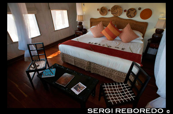 Interior de las tiendas del campamento Eagle Island Camp de Orient Express, en las afueras de la Reserva de Animales de Moremi, en Botswana. En Eagle Island Camp, el contacto con la naturaleza no está reñida con el confort. Cuenta con 11 lujosas tiendas con cama doble o dos individuales y vistas a la laguna. Las tiendas son suites muy cómodas y amplias con  cuartos de baño y vestidores que han sido diseñados para estar en armonía con el medio natural que los rodea. El campamento cuenta también con una impresionante suite privada. Apartada de las otras tiendas, dispone de una espaciosa cubierta con vistas y dos tumbonas. El escenario perfecto para relajarse y disfrutar del sol africano, con una piscina climatizada oculta entre los árboles para dar sombra y privacidad. La suite también posee una ducha doble y una hermosa bañera de cobre de estilo victoriano. Las instalaciones incluyen: Calentadores de agua individuales de gas para el agua caliente Tocador y lavabo doble  Mirador privado con hamaca y muebles de madera  Mini-bar Kit de limpieza para los zapatos Mosquitera y repelente de mosquitos Caja fuerte propia Teléfono para comunicarse entre los campamentos Artículos de aseo y tocador Marula Aire acondicionado / calefacción Puntos de energía de 240v CA y 32v CC  Secadores de pelo  Ventilador eléctrico de techo Enchufes de 110v/220v para máquinas de afeitar  Instalaciones para cargar las baterías de video  Iluminación 24 horas DC en las habitaciones Conexión a Internet  Teléfonos por satélite para la comunicación entre las tiendas  Comidas Comedor interior y exterior y zona de estar . Plataforma con vistas y Bar Fish Eagle – la forma ideal para observar la puesta de sol sobre el Delta. Hoguera con espacio para sentarse alrededor. Sala de conferencias Instalaciones     Gran piscina climatizada situada al lado de la laguna Senderos iluminados  Tiendas de curiosidades con artículos de aseo, accesorios de fotografía y vídeo, ropa de safari, arte local y objetos de artesanía  Comunicaciones por radio VHF e instalaciones de emergencias 24 horas  Proyector y pantalla deslizable  Teléfono por satélite disponible con coste adicional Telescopio Servicio de lavandería Biblioteca de consulta e instalaciones audiovisuales  Lista de referencia de la flora y fauna local, charlas y lecturas Kit de primeros auxilios Recepción y traslado de los huéspedes en el Aeropuerto de Maun por el representante de Orient-Express Traslado desde y hasta los hoteles para los huéspedes que pasen la noche en Maun  Todos los vuelos Air Botswana y Air Namibia son automáticamente reconfirmados para los huéspedes  Puede organizarse un vuelo charter privado directo desde el aeropuerto Johannesburg Lanseria al campamento 